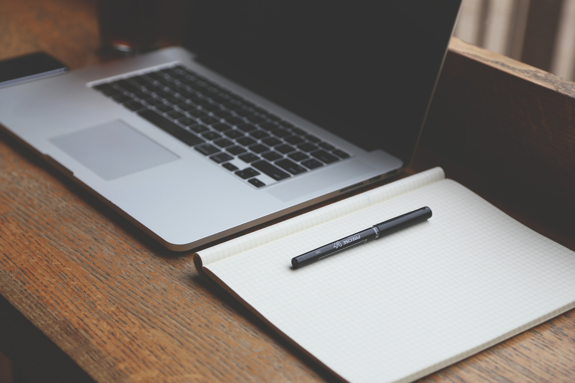Laptop und Notizbuch mit Stift